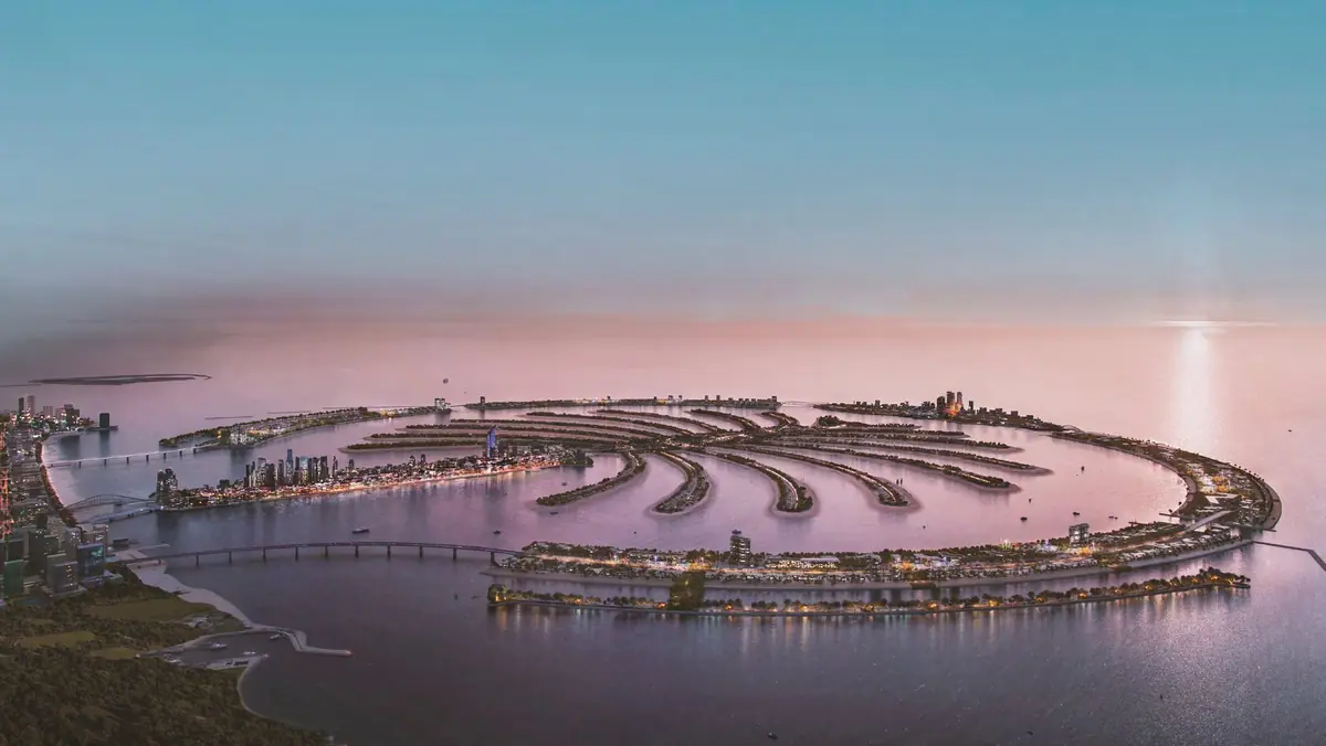 Palm Jebel Ali from the air at dusk, its fronds reaching into the Gulf